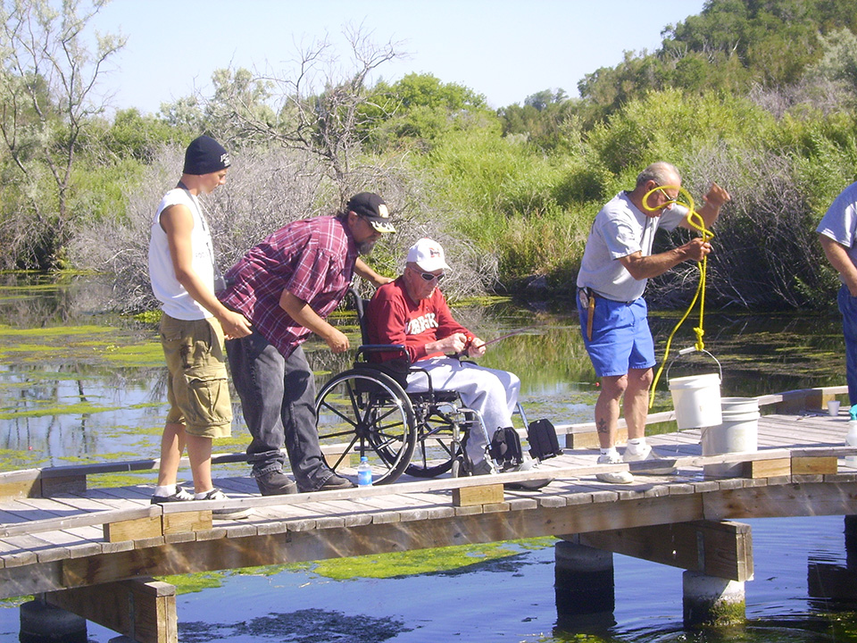 Group of men fishing including Veteran in Wheelchair